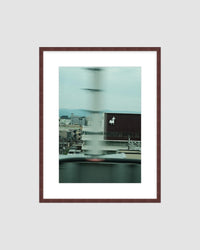 Framed artwork of a cityscape with a blurred background on a light gray background