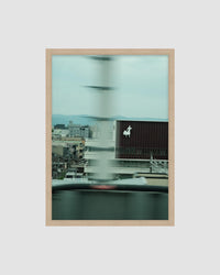 Framed artwork of a cityscape with a blurred effect on a light gray background