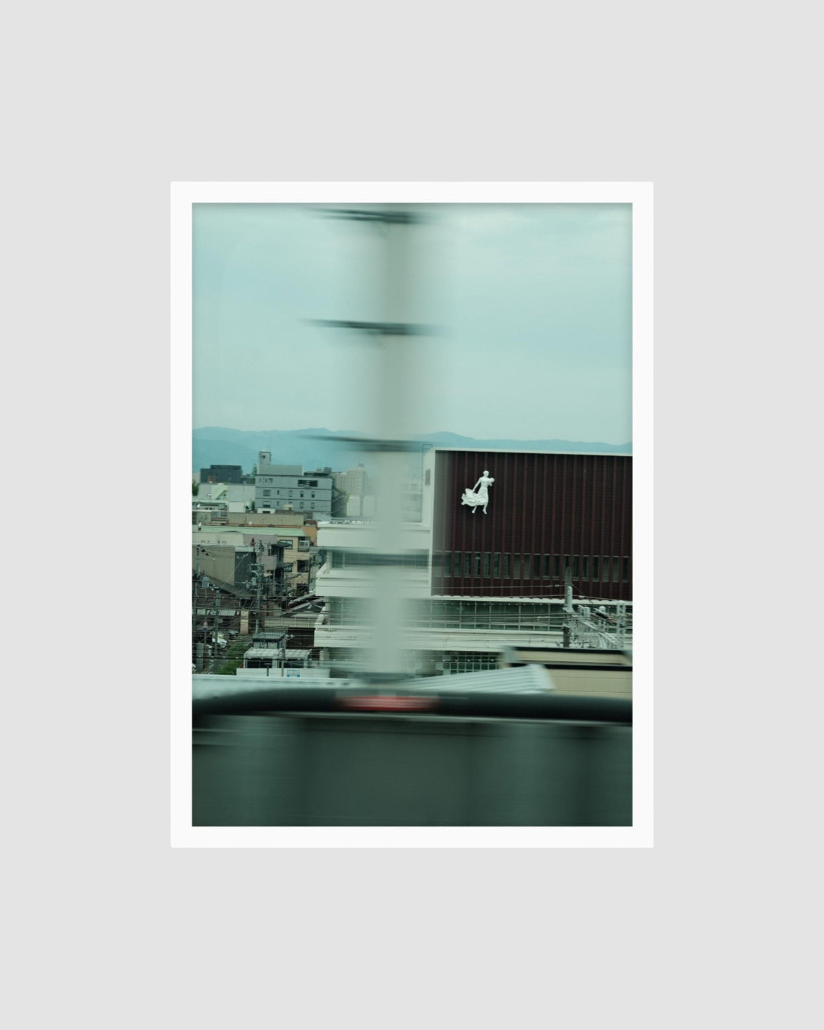 Cityscape through a blurred window with modern buildings and a clock tower.