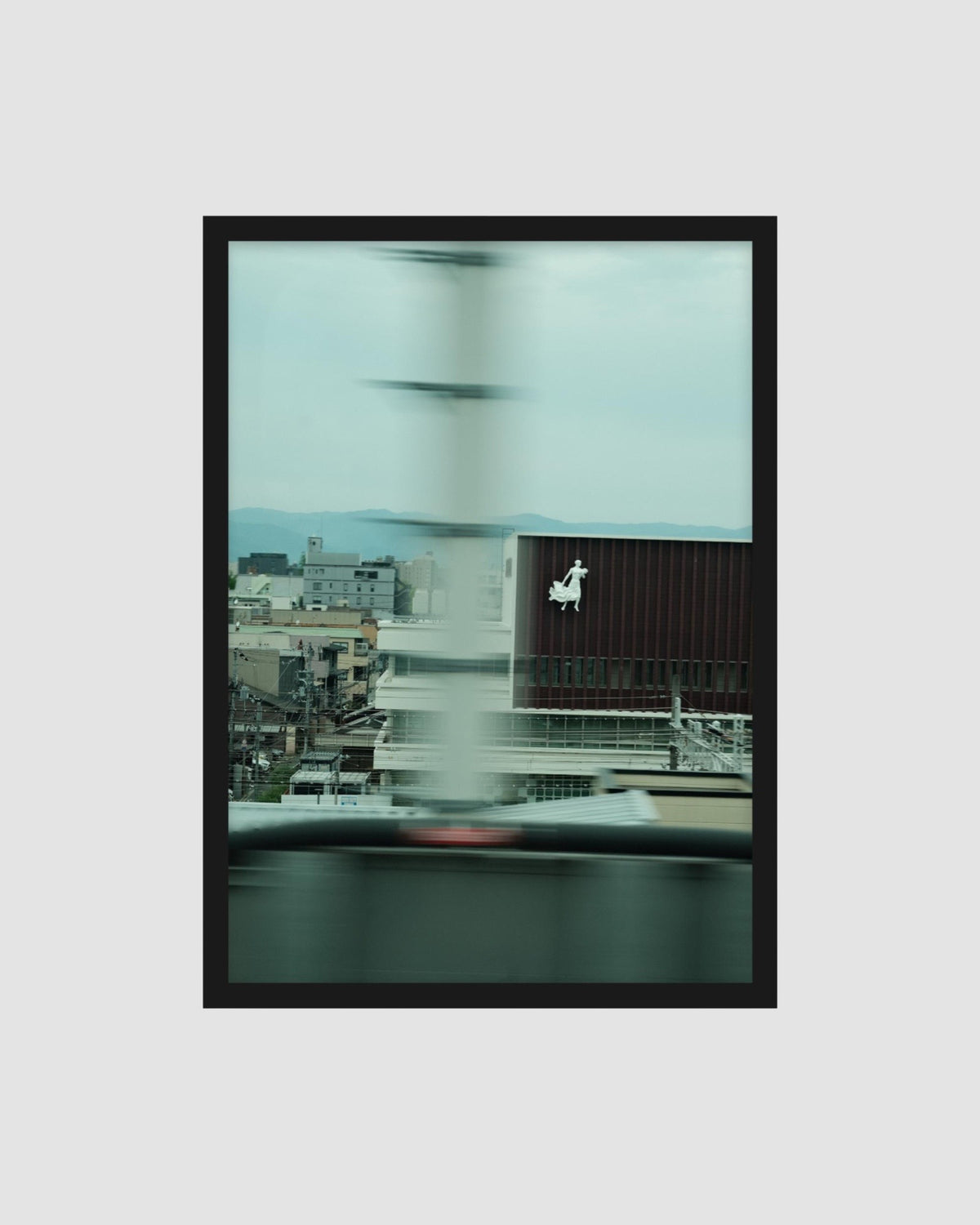 Framed artwork of a cityscape with a blurred effect on a light gray background