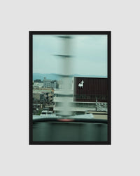 Framed artwork of a cityscape with a blurred effect on a light gray background