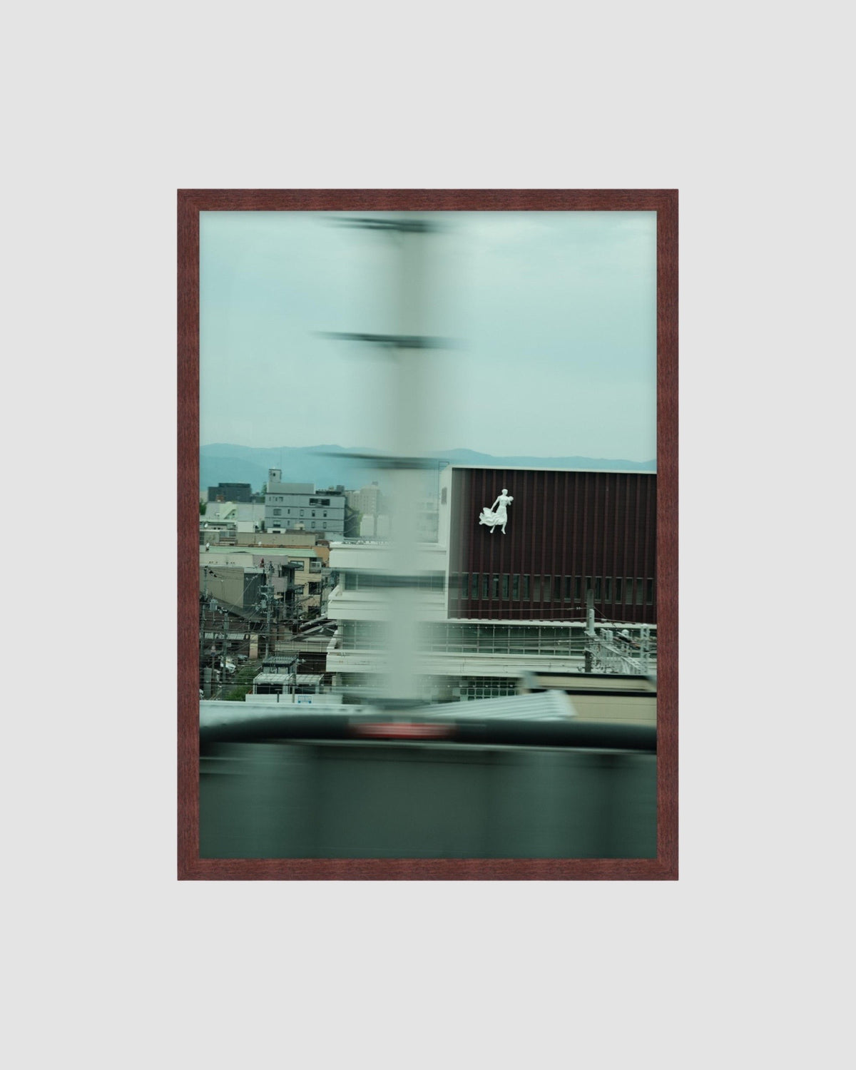 Framed artwork of a cityscape with a blurred effect on a light gray background