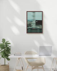 Modern office setup with a framed picture on the wall, desk, chair, and plant.