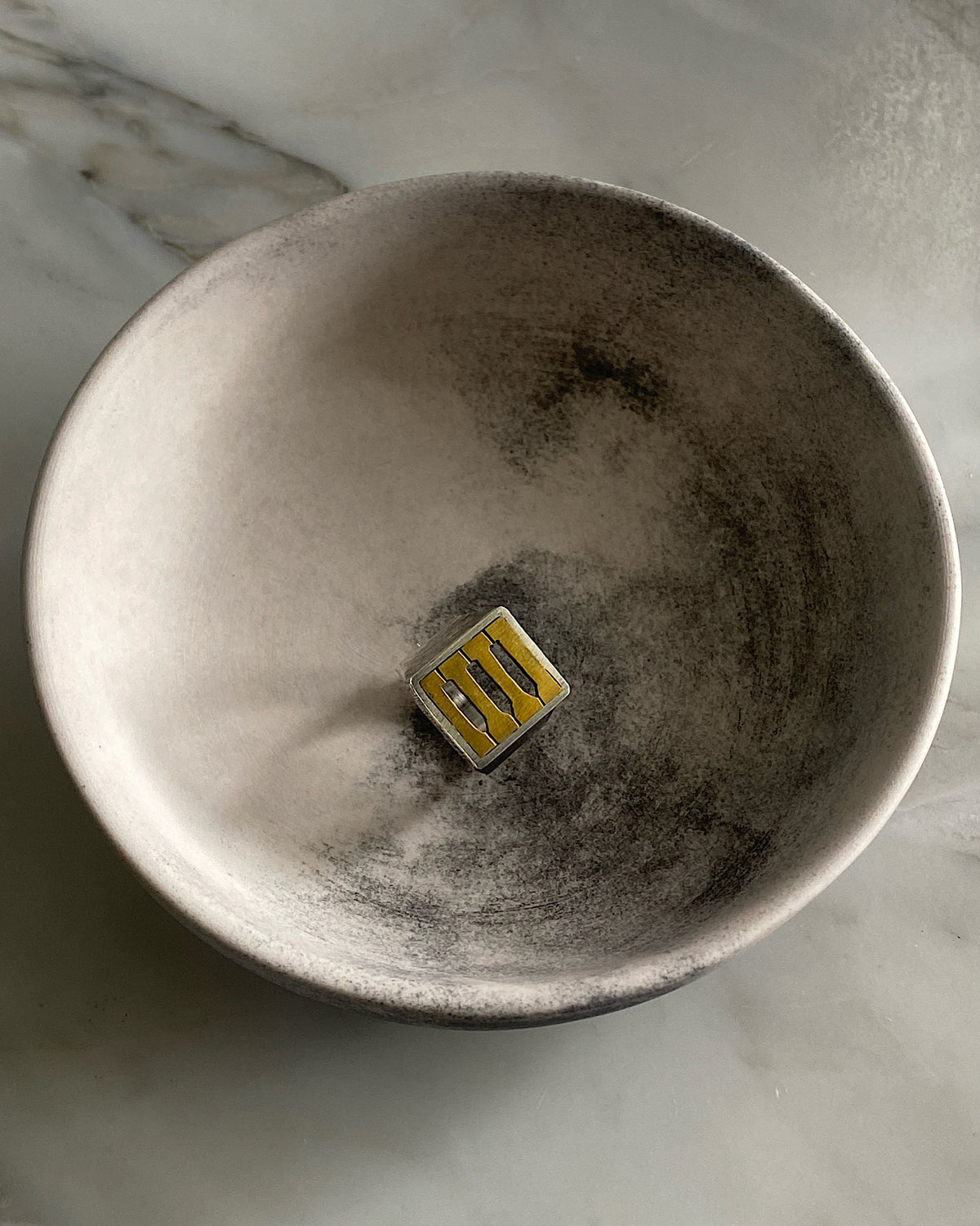 a silver and brass ring sits in a bowl. Available at the Pared Store, Surry Hills