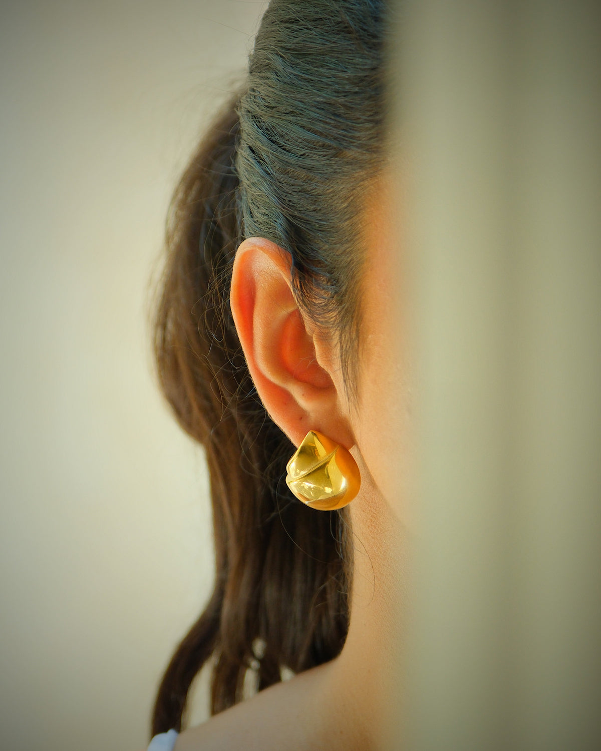 Model wears tess gold earrings