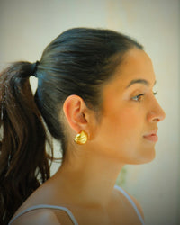 Model wears tess gold earrings