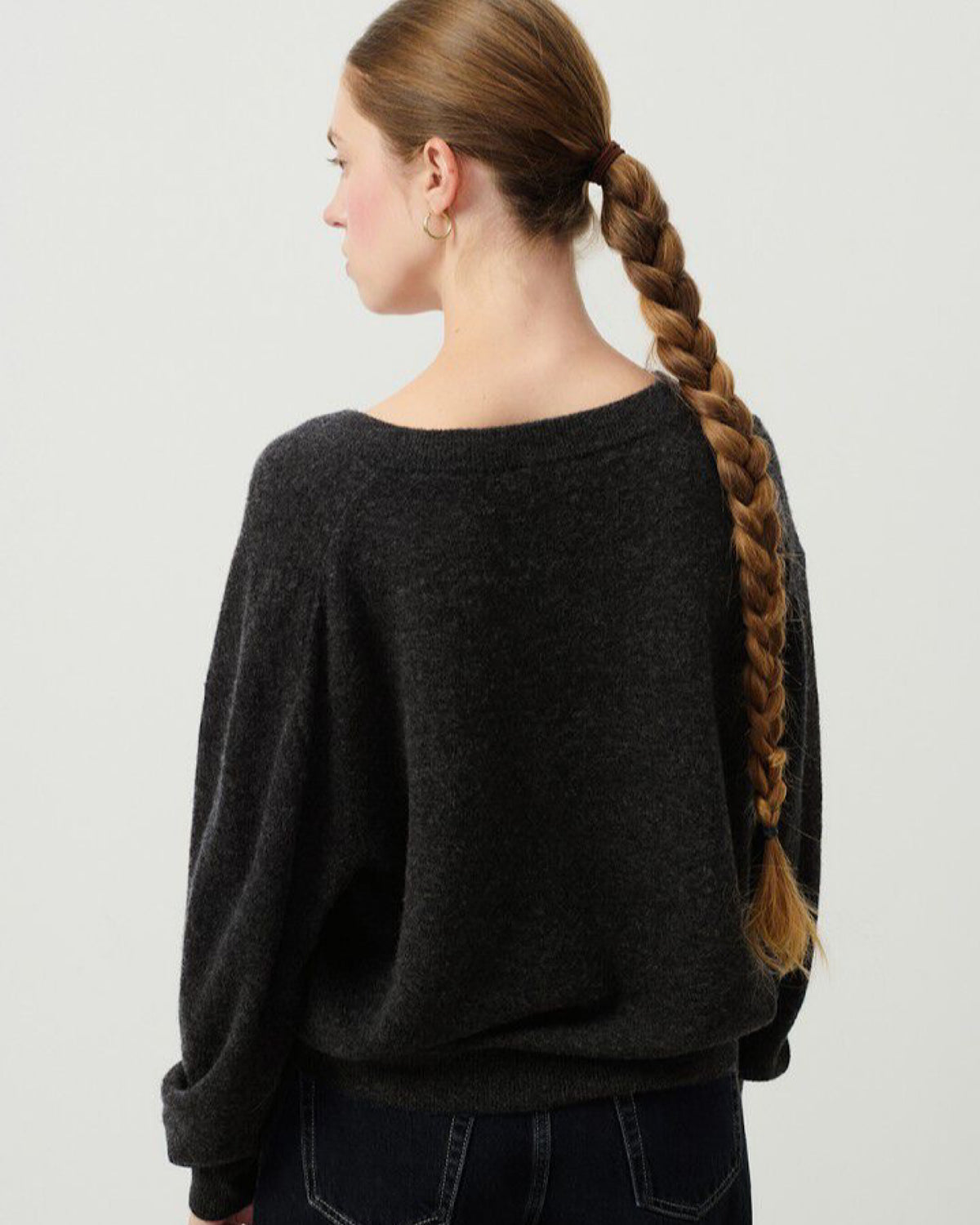Model wears a dark charcoal v neck Razow Sweater from American Vintage