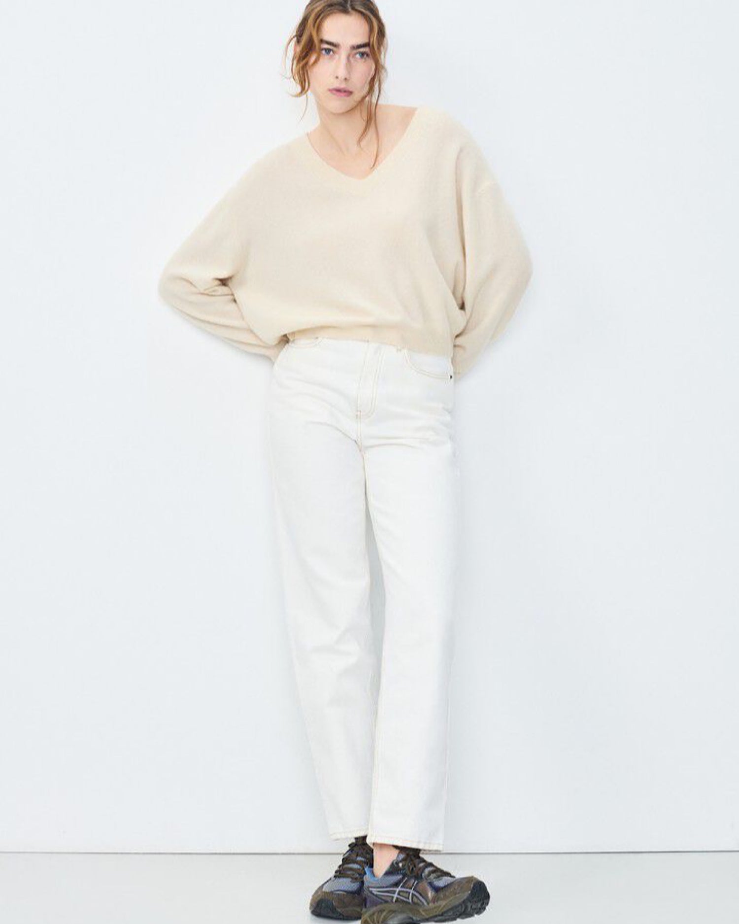 Model wears a cream v neck Razow Sweater from American Vintage