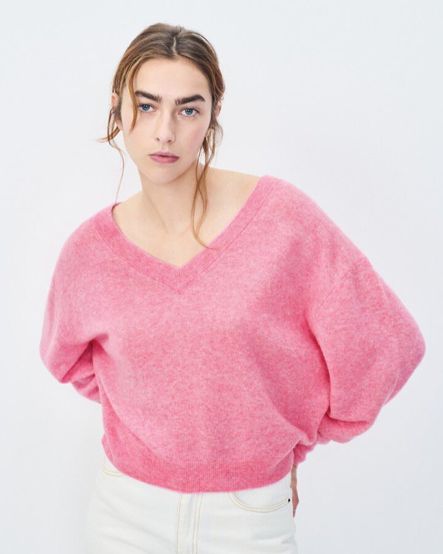 Model wears a pink v neck Razow Sweater from American Vintage