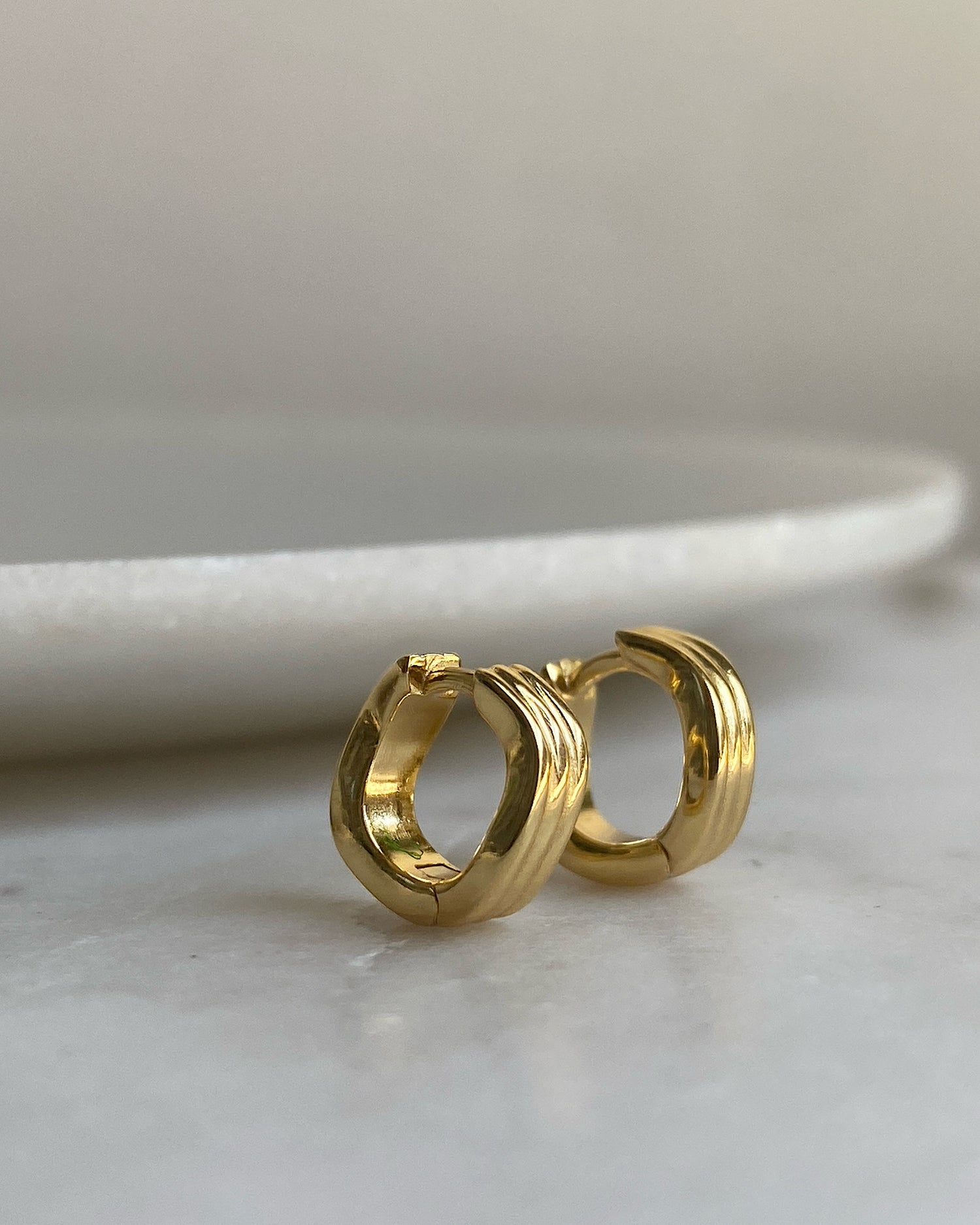 A gold pair a wave shaped small hoops