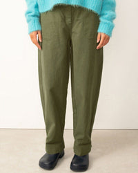 Person wearing green pants and a blue sweater on a white background
