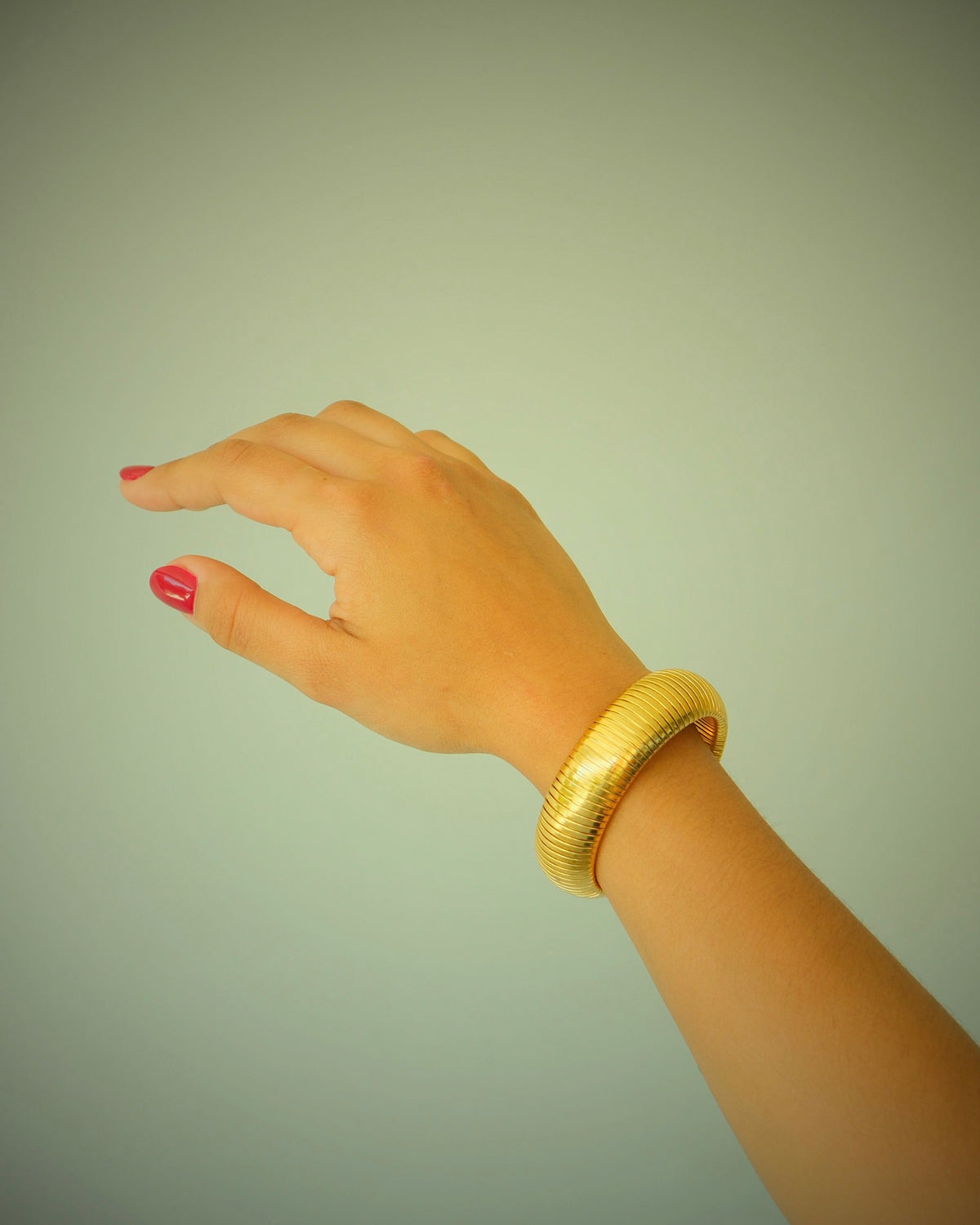 Thick gold snake bangle on model