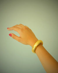 Thick gold snake bangle on model