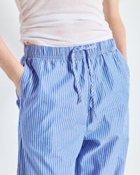 Blue striped pants worn by a person on a white background