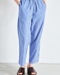 Blue striped pants worn by a person on a white background