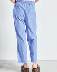 Blue striped pants worn by a person on a white background