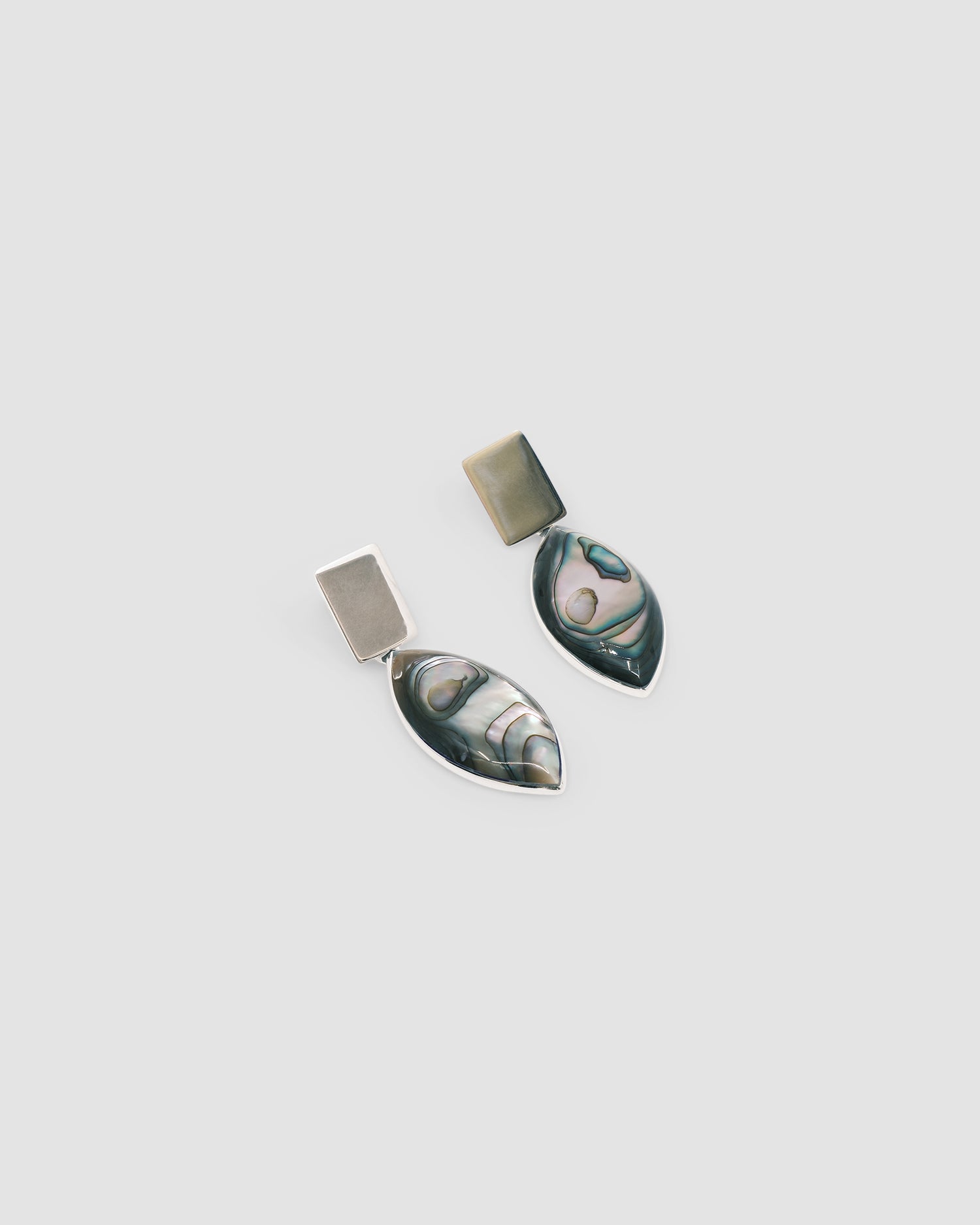 abalone & silver earrings against a grey background