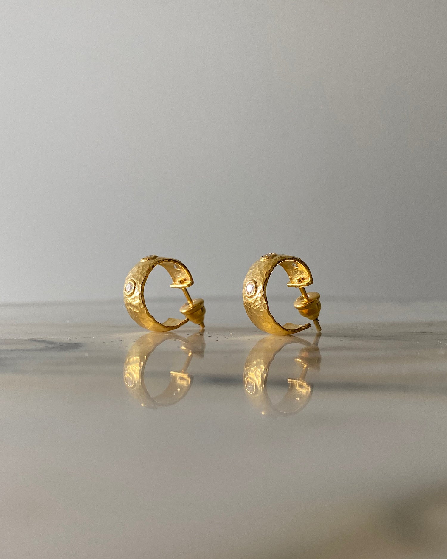 small gold hoop earrings with stud backs and clear crystals dotted along them