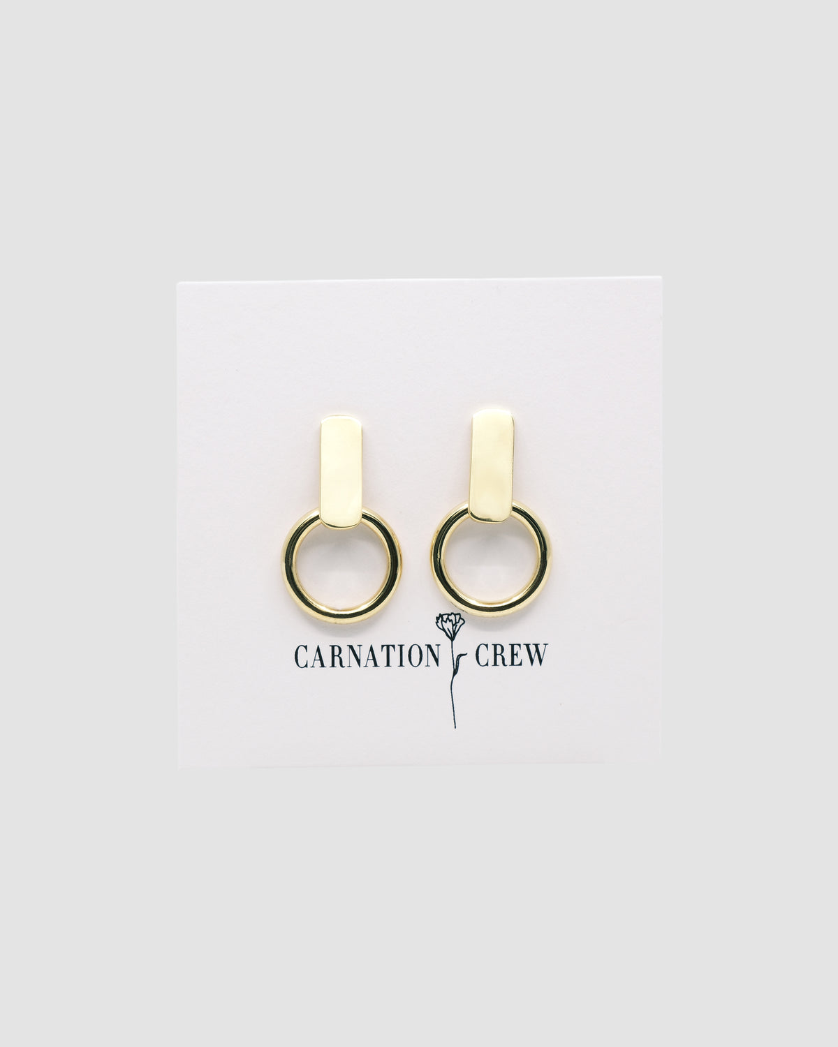 Gold rectangular studs with open hoops handing from them on a card