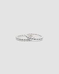 two silver ball bangles rest on each other on a grey background