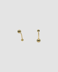 gold bar earrings with a ball at each end on a grey background