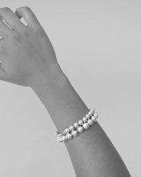 two different sized ball bracelet's on an arm