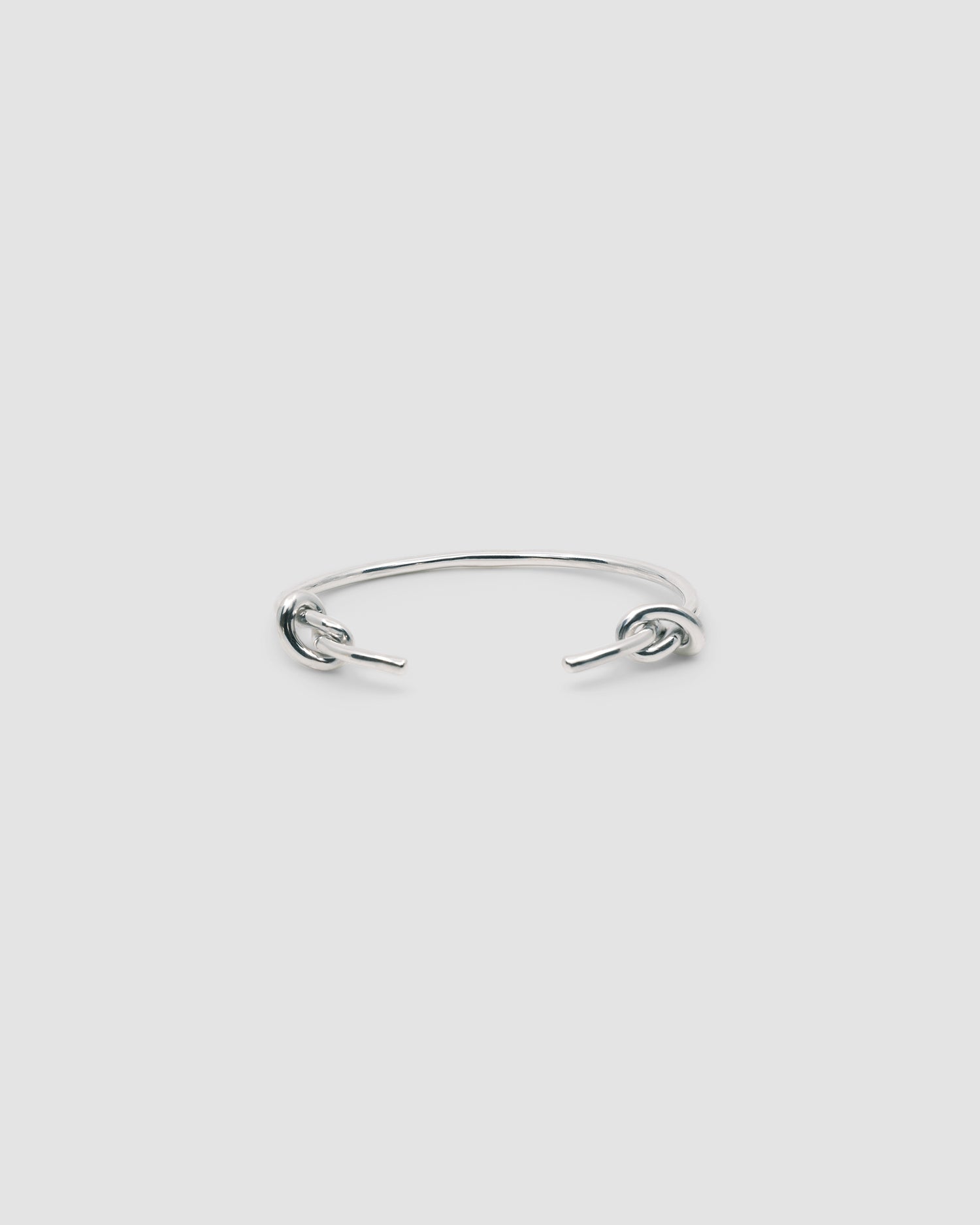 Silver open style bangle with two knots at the end