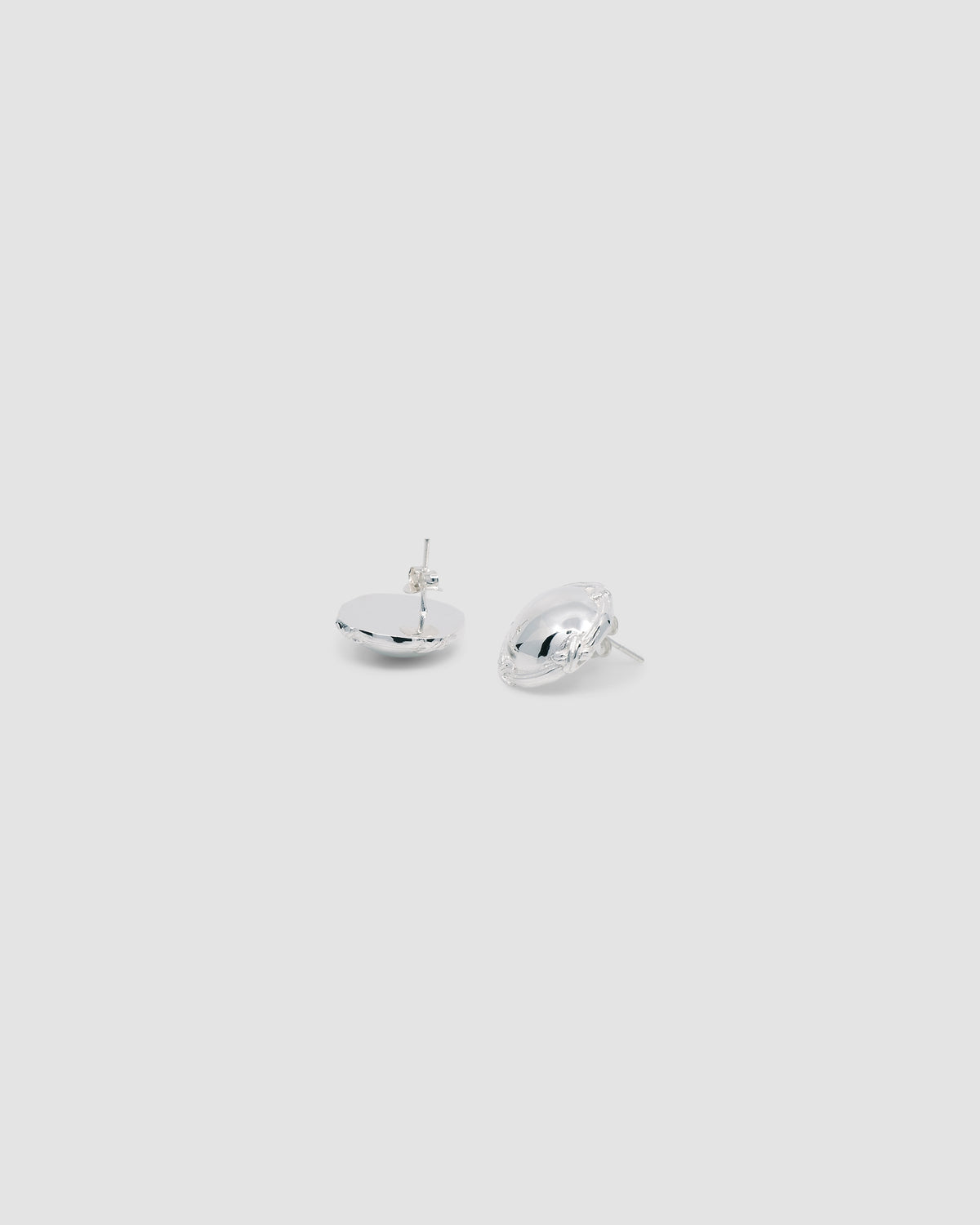 silver round earrings lying on a grey background