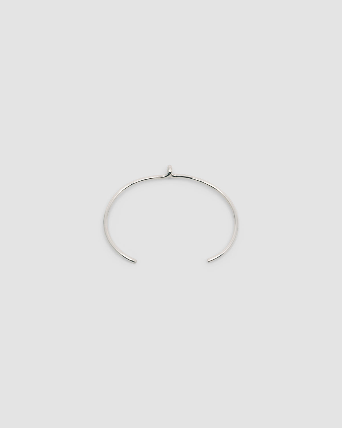 thin open silver cuff with a central loop