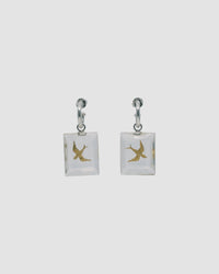 gold swallow bird charms are encased in a clear resin rectangle and dangle from a silver hoop earring