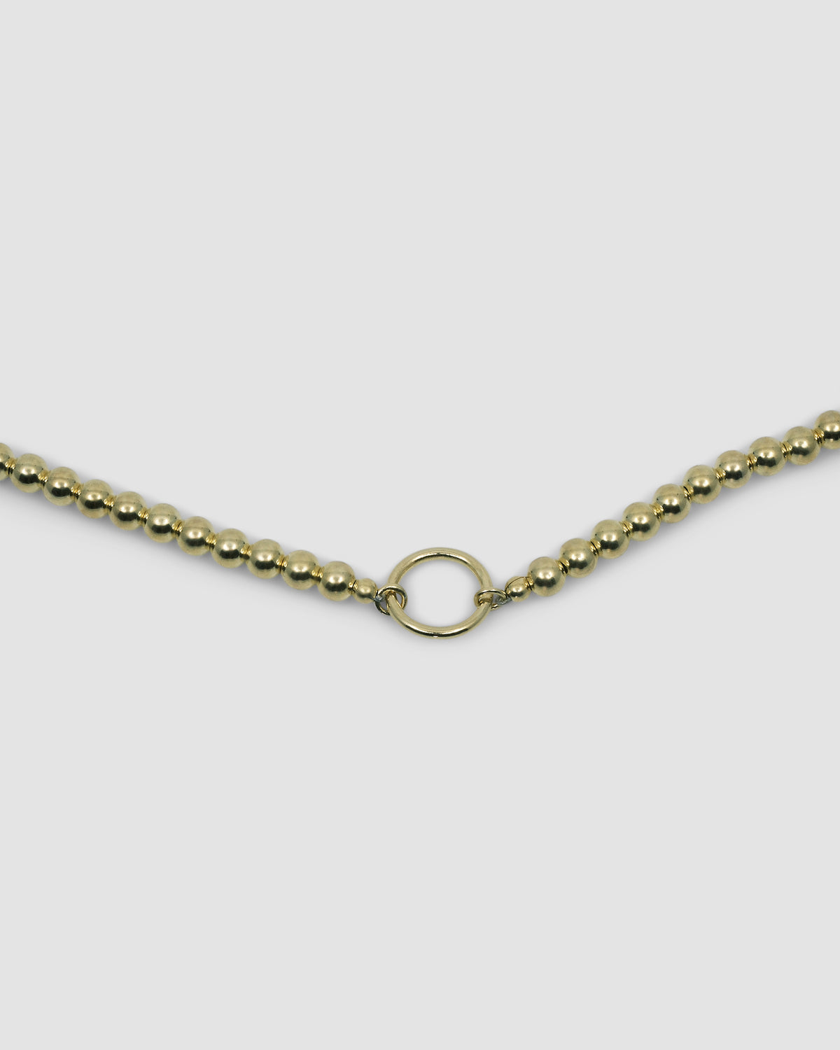 a gold ball chain with a central ring for hanging charms