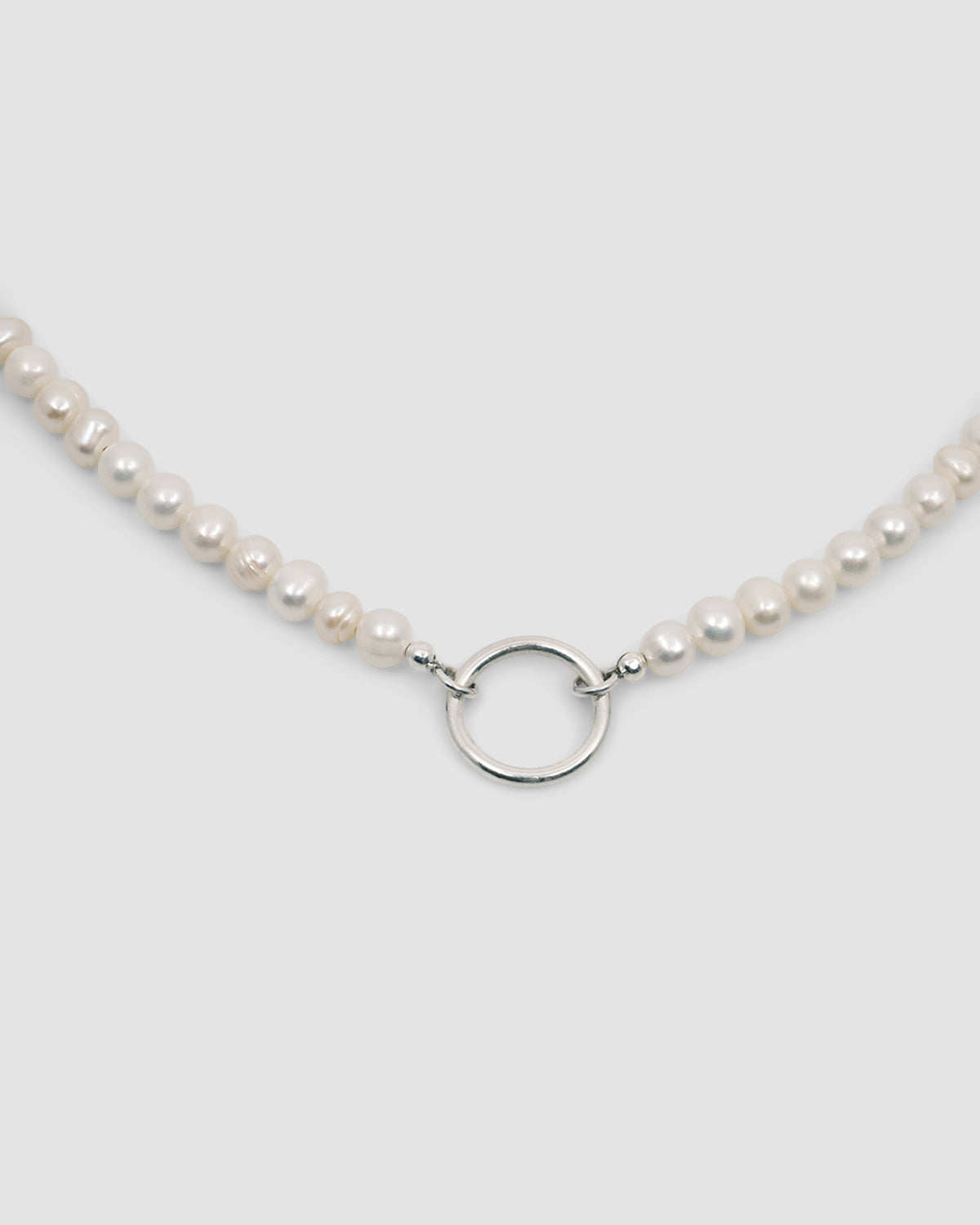 pearl necklace with a silver charm ring attached