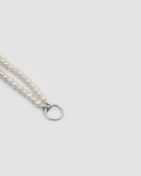 pearl necklace with a silver charm ring attached