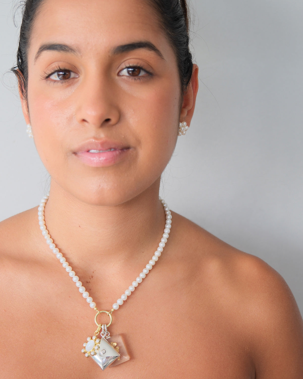 model wears a necklace with a group opf charms