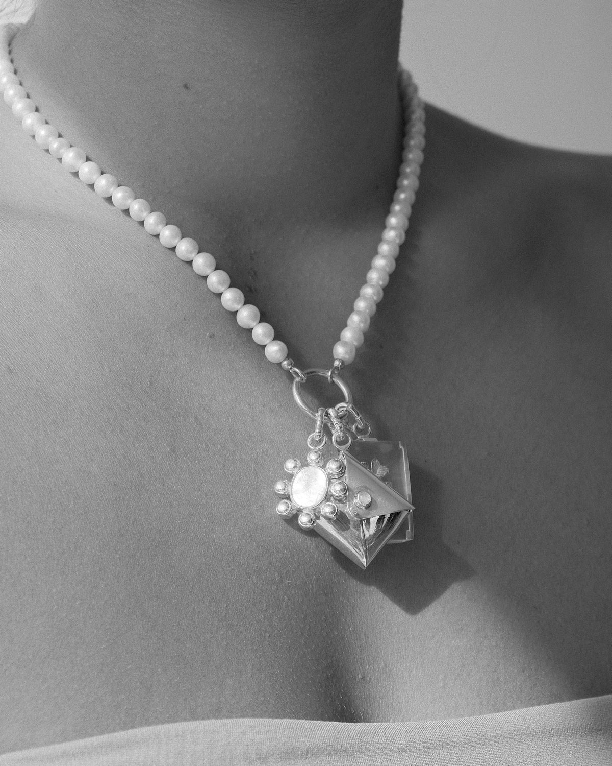 a charm pearl necklace with charms on a model