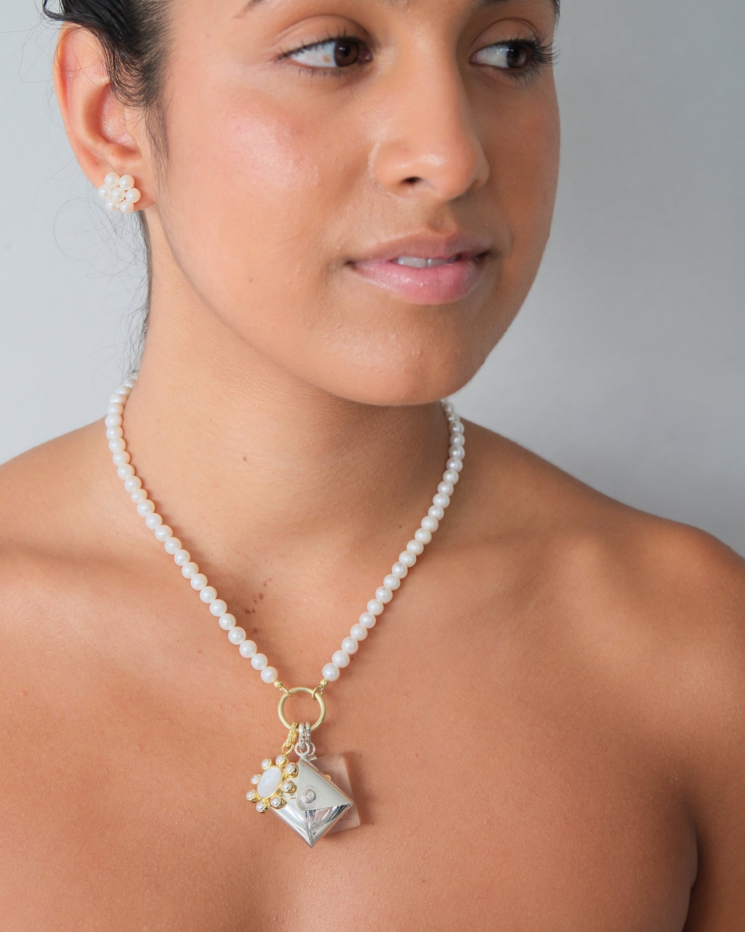 a pearl necklace with charms on a model