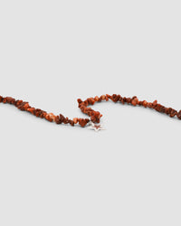 a red coral jagged necklace with a central coral and silver star