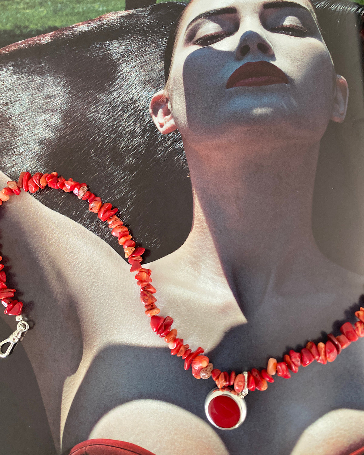 a red coral jagged necklace with a central round coral and silver pendant