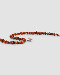 a red coral jagged necklace with a central round coral and silver pendant