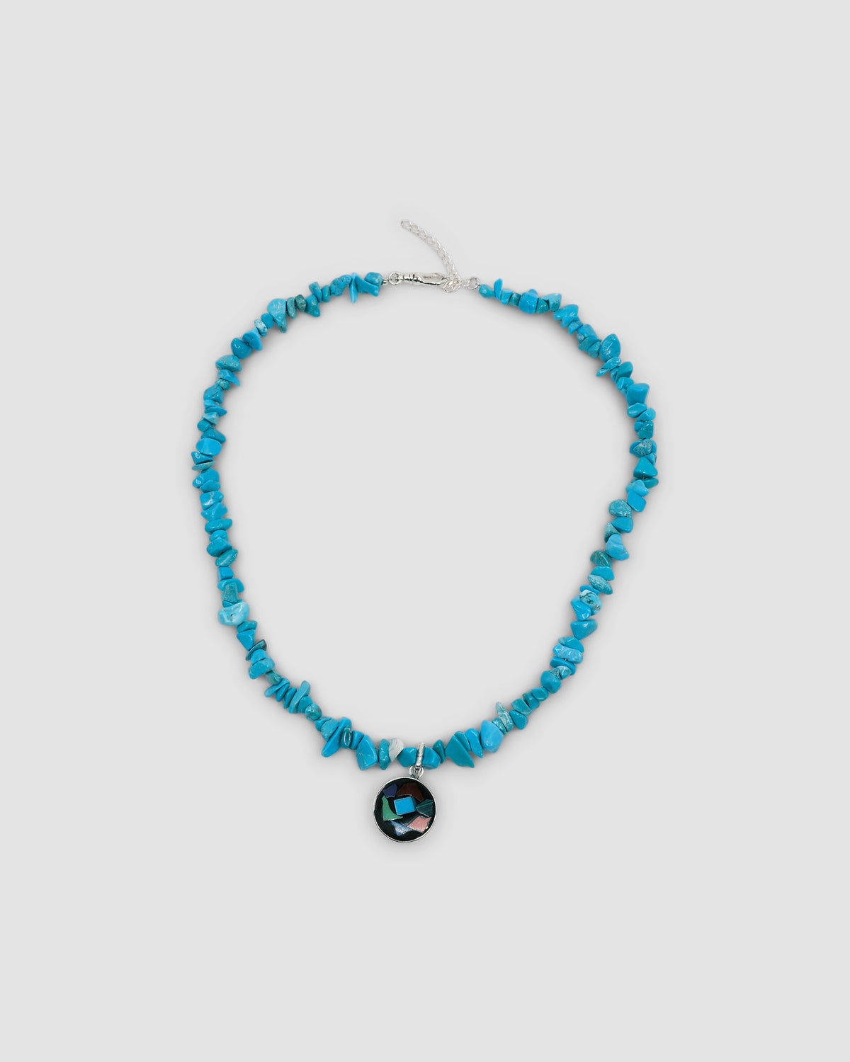 a turquoise jagged necklace with a central round multi colour and silver pendant