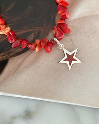 a red coral jagged necklace with a central coral and silver star