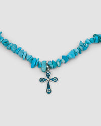 blue turquoise jagged stone necklace with a pendant featuring turquoise and silver cross