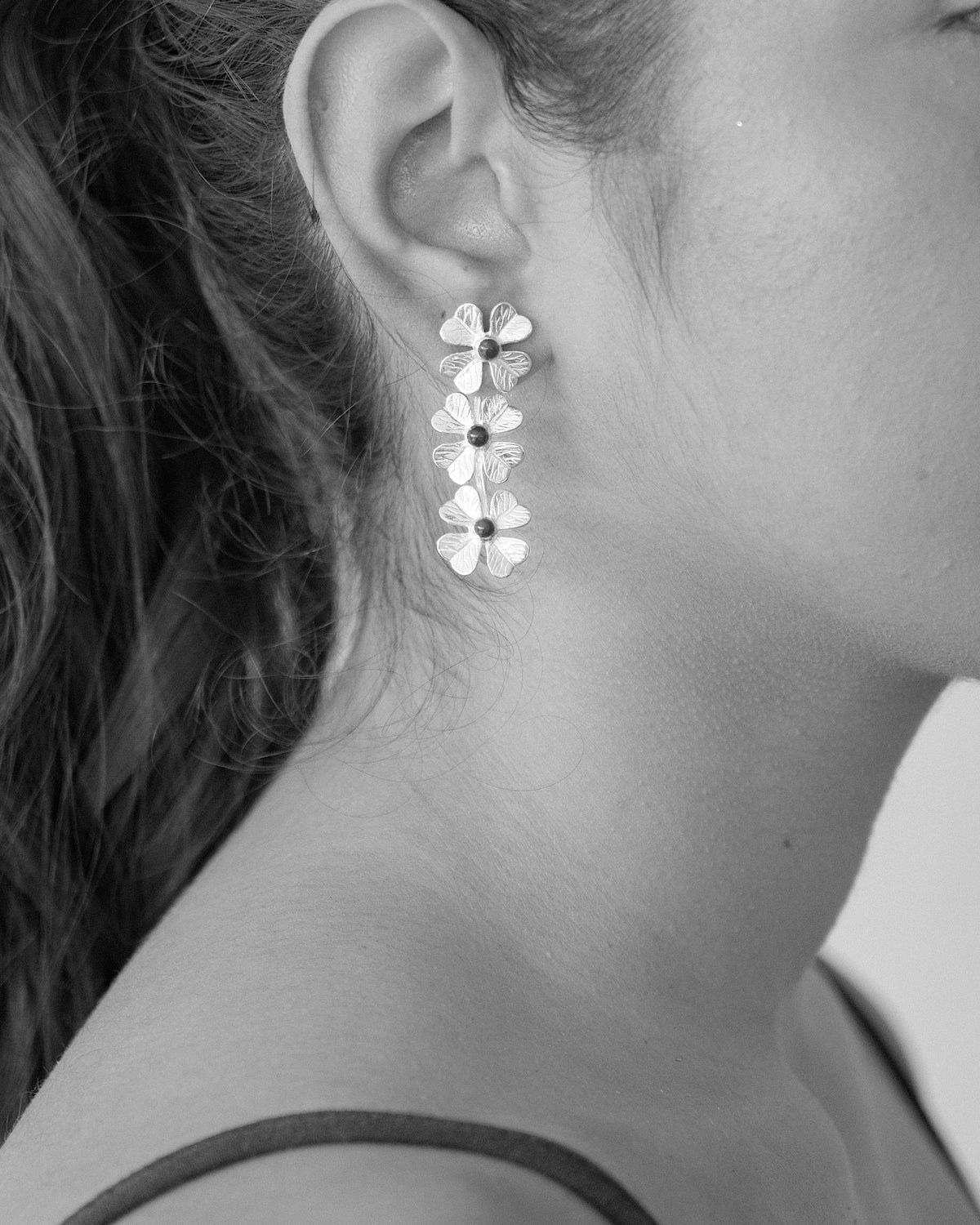model wears triple flower drop earrings