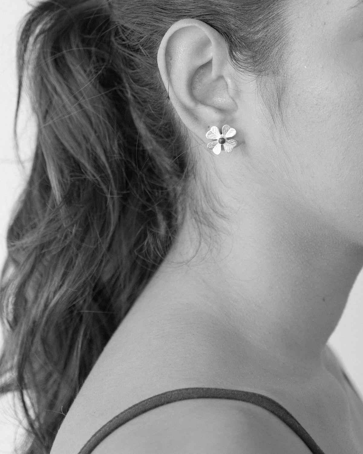 model wears single flower earrings