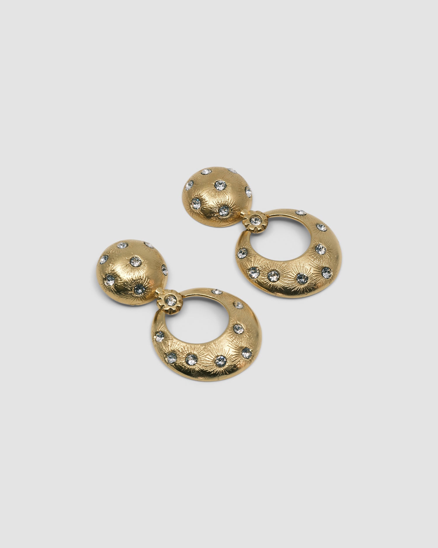 Gold earrings featuring a round stud top and open circle drop inlaid with crystals