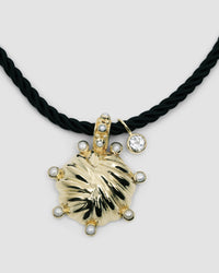 unusual striped gold pendant with pearls dotted around sit on a black cord pendant with a crystal