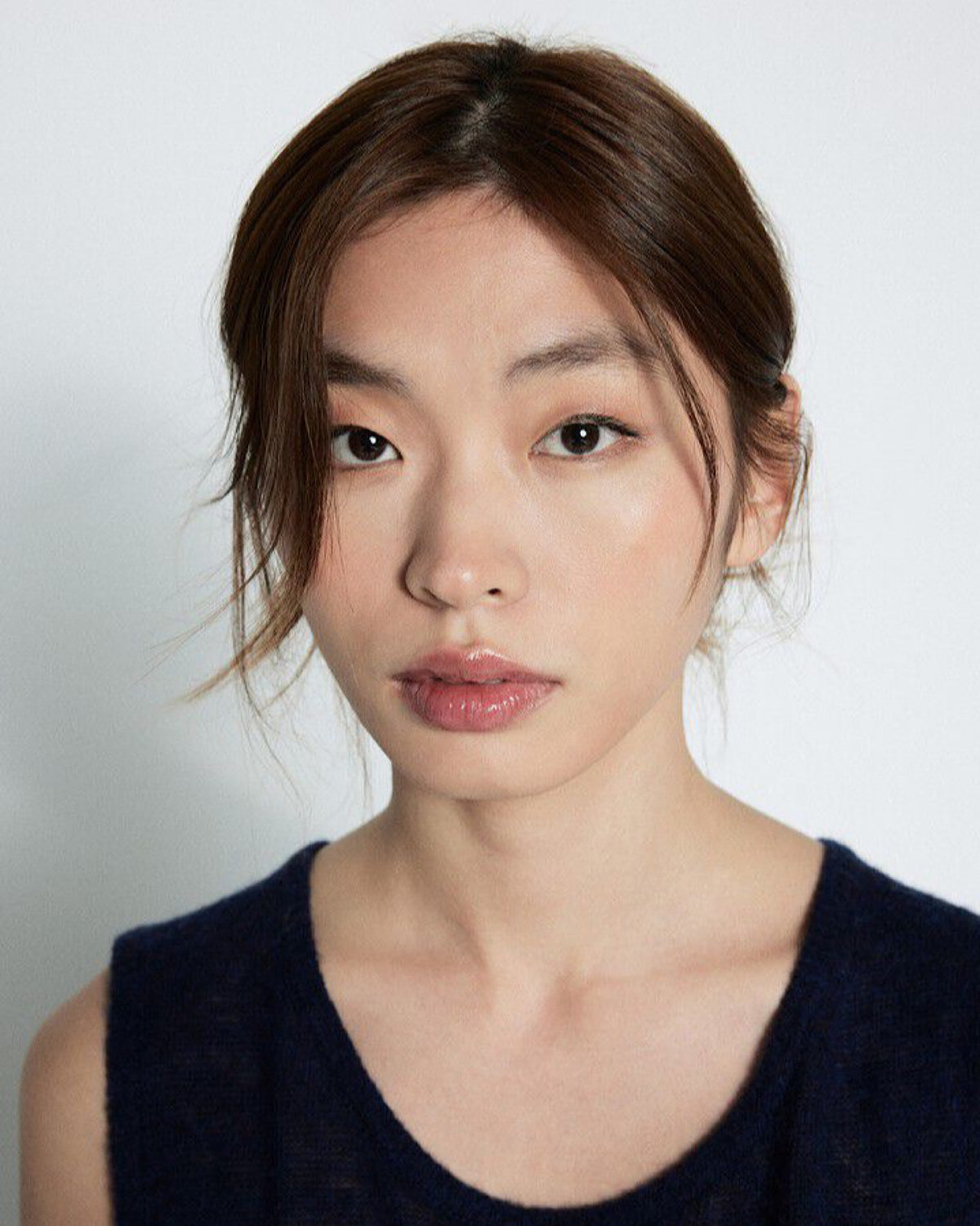 Woman wearing a dark blue sleeveless top against a plain background, available at The Pared Store