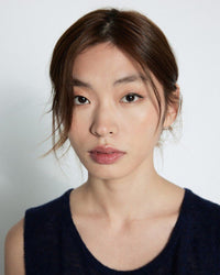 Woman wearing a dark blue sleeveless top against a plain background, available at The Pared Store