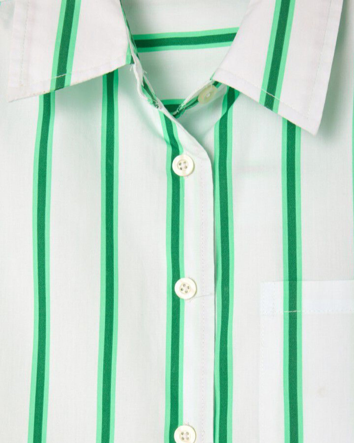 Close-up of a white shirt with green vertical stripes and buttons.