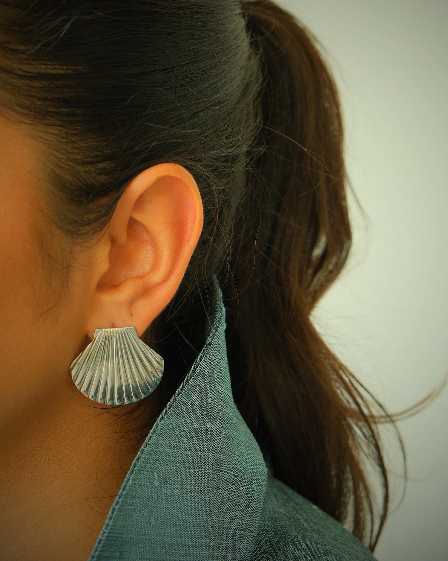 model wears silver shell earrings